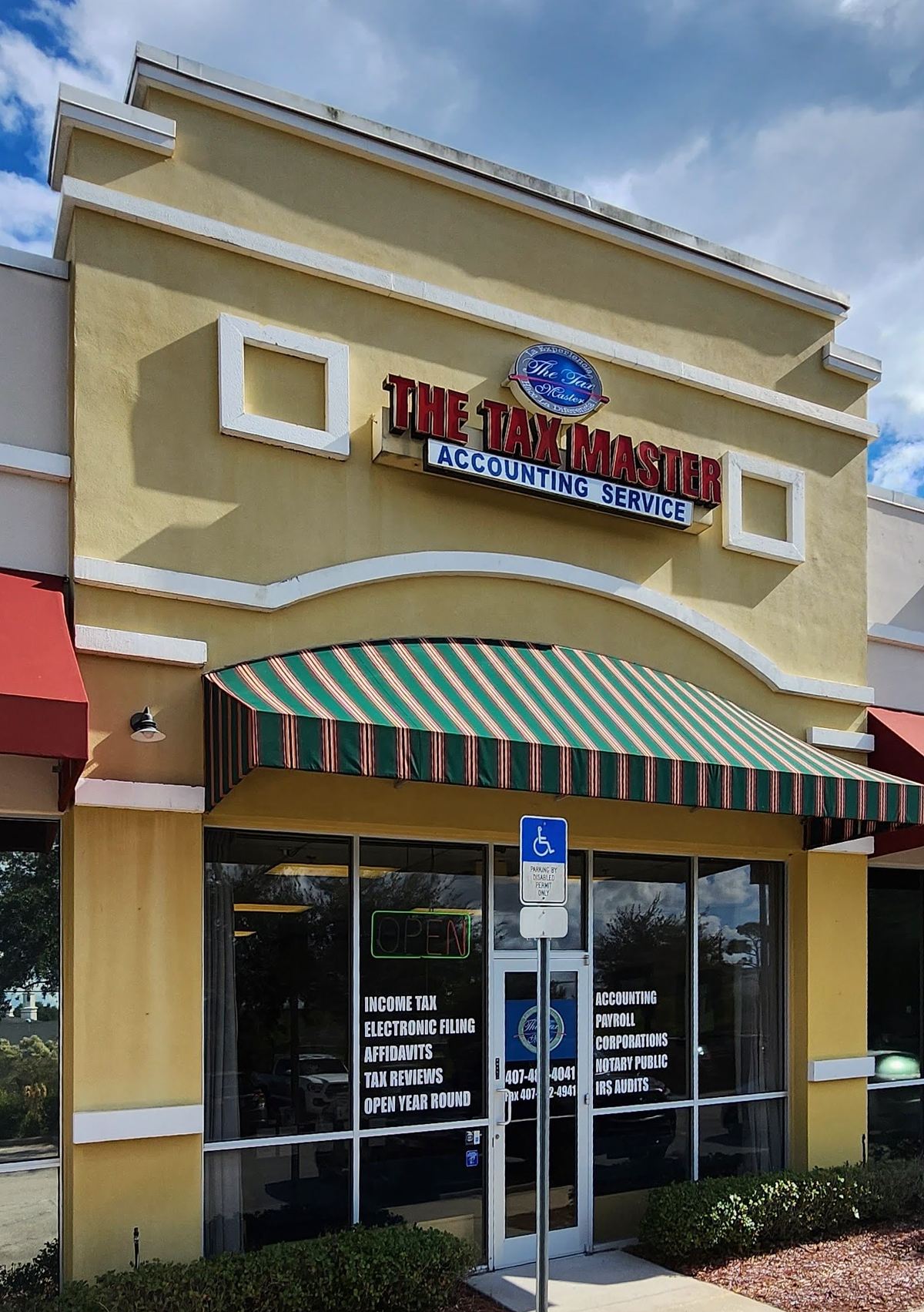 The Tax Master storefront at 222 Neighborhood Market Rd #104 in Orlando — the red "The Tax Master" sign above a green striped awning